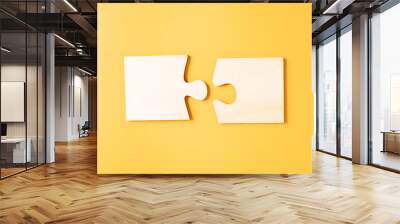 Matching two pieces jigsaw puzzle on yellow background. Creative and idea concept. Wall mural