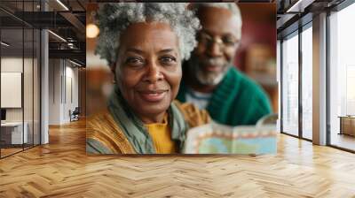 Senior couple looking at a map together during a winter vacation. Wall mural