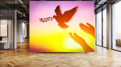 Silhouette pigeon flying carry olive branch two hands in air vibrant sunlight sunset sunrise background. Freedom making merit concept. Animal people hope pray holy faith. International Day of Peace. Wall mural