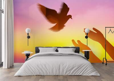 Silhouette pigeon return coming to hands in air vibrant sunlight sunset sunrise background. Freedom making merit concept. Nature animal people hope pray holy faith. International Day of Peace theme. Wall mural