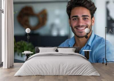 Smiling young man in casual attire looking at camera. Wall mural