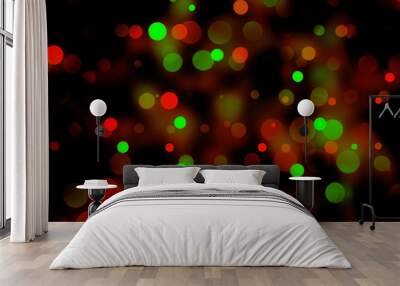 Festive bokeh illumination with warm red and green lights on black Wall mural