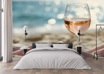 Close-up of rose wine glass resting on a beach towel Wall mural