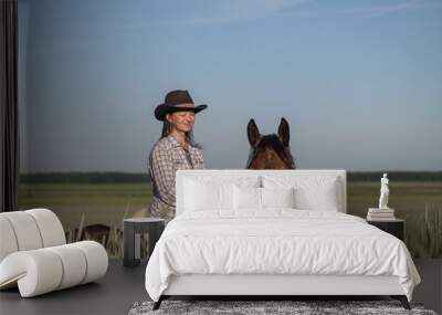 Portrait of a young beautiful dark-haired girl with a horse outdoors. Wall mural