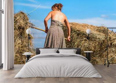 The girl on the farm cleans the straw. Wall mural