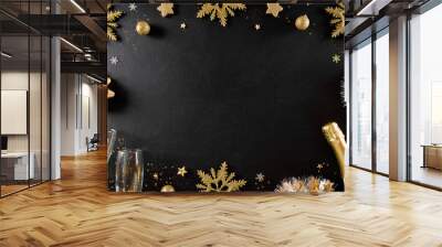 Christmas and New Year holidays background concept made from champagne, glasses, stars, snow flake with golden glitter on black wooden background. Wall mural