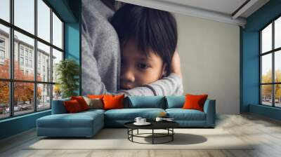 Closeup sad little boy being hugged by his mother at home. Parenthood, Love and togetherness concept. Wall mural