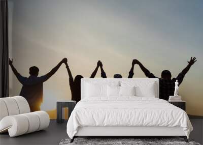 Group of happy friends are having fun with raised arms together in front of mountain and enjoy sunrise sunset showing unity and teamwork. Friendship happiness leisure partnership team concept. Wall mural