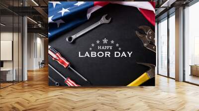 Happy Labor day concept. American flag with different construction tools on black table background, with copy space for text. Wall mural