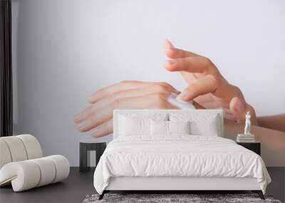 Healthcare concept. Closeup shot of  young woman hands applying moisturizing hand cream. Wall mural