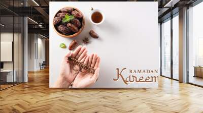 Table top view image of decoration Ramadan Kareem background,  dates fruit, coffee and hand with rosary beads. Wall mural