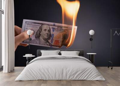 Woman hand holding burning burning dollar cash money over black background - business finances, savings and bankruptcy concept. Wall mural