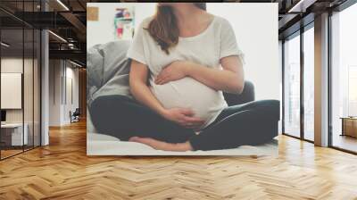 Pregnant woman touching her belly Wall mural