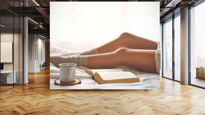 Soft photo of woman legs on the bed with old book and cup of coffee Wall mural