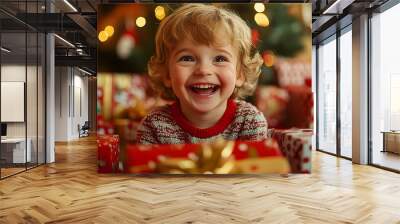 A joyful child smiles amidst festive Christmas presents. Wall mural