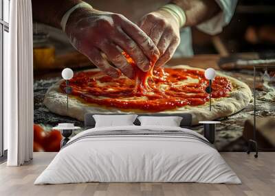 A chef's hand spreads tomato sauce on a pizza dough. Wall mural