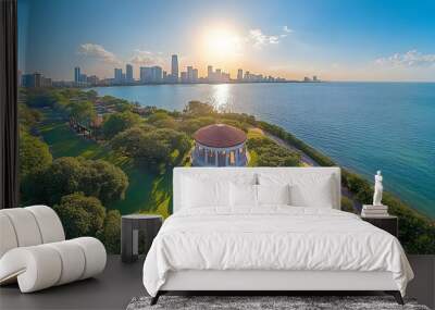 A panoramic view of a cityscape with a gazebo in the foreground and a sun setting over the water. Wall mural