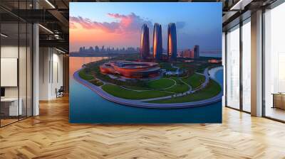 A panoramic view of a modern city skyline with skyscrapers and a large building on an island, surrounded by water and a colorful sky at sunset. Wall mural