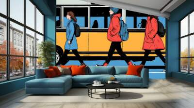 Three people in winter clothes walk past a yellow bus. Wall mural