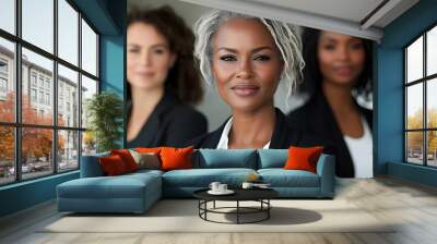 Three professional women posing confidently in business attire. Wall mural