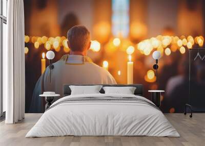 A man in white robes stands in a church, with candlelight shining in the background. Wall mural