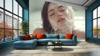 A young woman with eyes closed relaxes in a luxurious bubble bath. Wall mural