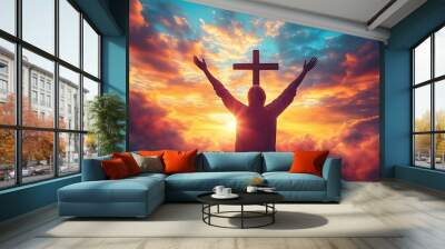 Silhouette of a person with outstretched arms in front of a cross against a vibrant sunset. Wall mural