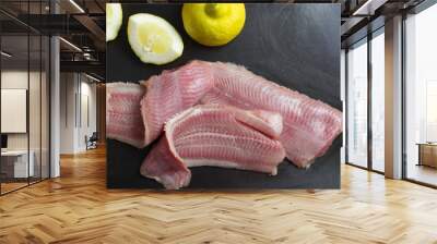 Fresh, unroasted African catfish fillet. Black background Wall mural