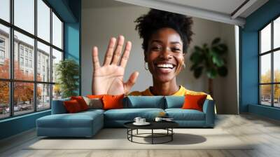 Happy black woman waving during video call at home Wall mural