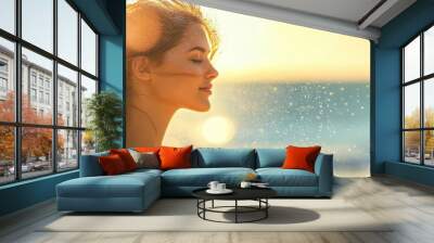 A serene portrait of a woman by the beach, her hair gently flowing in the breeze, capturing a moment of tranquility and beauty. Wall mural