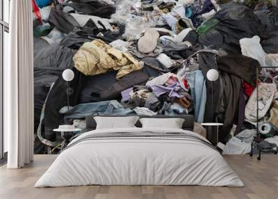 Close-up of pile of discarded clothes and other waste dumped at side of street in the West Midlands Wall mural