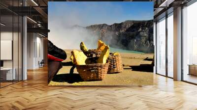 View of the Ijen caldera and of a miner close the sulfur boulders Wall mural