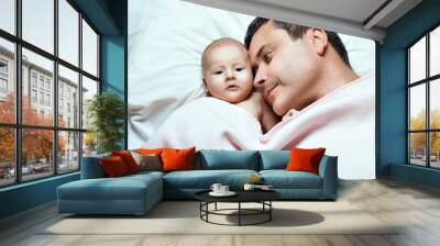 Father and his baby girl lying under a blanket. Father watching daughter Wall mural