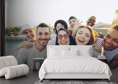 Point of view shot of happy friends taking selfe on roof at summer party laughing, posing and enjoying good company. Happiness, leisure and modern technology concept. Wall mural