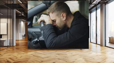 Young man sitting inside car is very upset and stressed Wall mural