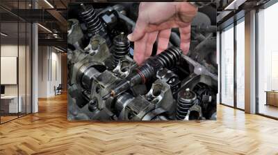 Car mechanic fixing modern diesel engine, closeup of hand removing injectors from cylinder head Wall mural