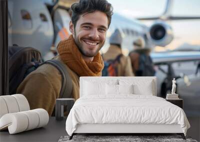 Young man catching a plane at the airport to travel on summer vacation with a smile, excited for her flying trip and ready for his vacation adventure with copy space Wall mural