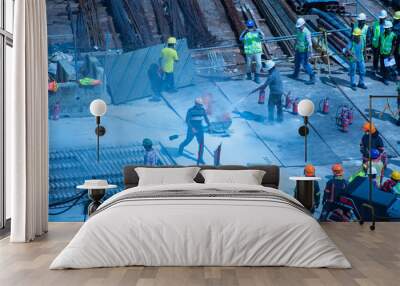 Construction workers wearing helmets at a construction site learning fire fighting skills Wall mural