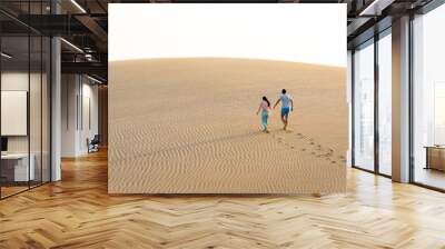 Couple walking together on sand dune Wall mural