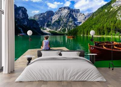 Woman relaxing on Pier at Lake Braies also known as Pragser Wildsee  in beautiful mountain scenery. Amazing Travel destination Lago di Braies in Dolomites, South Tyrol, Italy, Europe. Wall mural