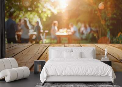 Empty wooden table and blurred view of a group of people having BBQ barbecue outdoors. Wood desk in front of a natural garden background. Summer lifestyle concept. Wall mural