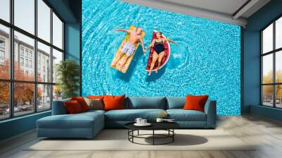 Above vertical view of people old senior couple taking hands with love and having fun on the blue clear swimming pool together enjoying the summer holiday vacation with trendy coloured lilos mattress Wall mural