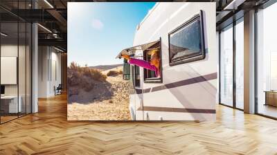 Adult tourist woman opening camper van window to enjoy the sun and freedom. Concept of travel people for summer holiday vacation inside camping car motorhome vehicle. Freedom nomad lifestyle Wall mural