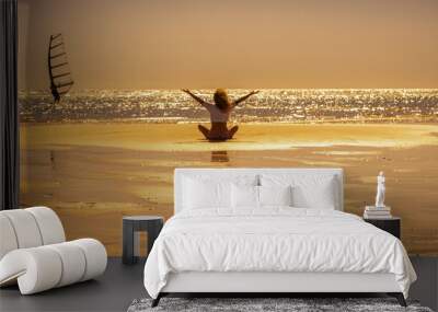 Banner header for tourist and summer holiday vacation people lifestyle. Enjoyed and overjoyed female viewed from back sitting on the sand at the beach with ocean and golden sunset in background Wall mural