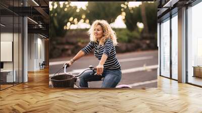 Beautiful and cheerful adult young woman enjoy bike ride in sunny urban outdoor leisure activity in the city - happy people portrait - trendy female outside having fun Wall mural