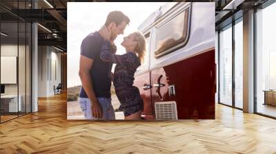 beautiful caucasian couple young kiss and love two people outdoor near a vintage red van. backlight and nice leisure activity for vacation and travel concept. happiness for young man and woman Wall mural