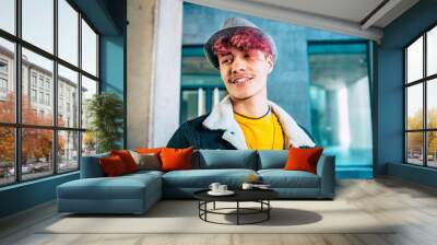 Beautiful diversity young people concept with caucasian cheerful coloured hair teenager male with urban wall in background - alternative trendy lifestyle and colors wear man - diverse generation z Wall mural