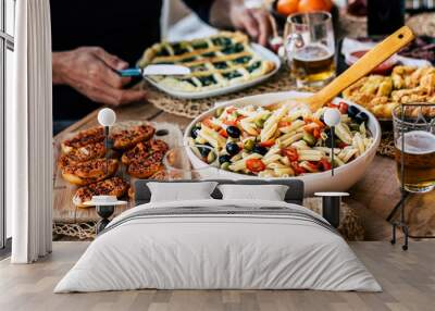 Close up of tasty and colorful rustic table full of food -italian pasta salads. and gourme ishes beer on glasses - people enjoying and celebrating friendship together at home or restaurant Wall mural