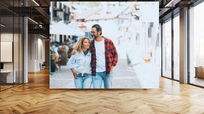 Cute adult couple waling together on the town street. Shopping and tourism activity. Happy people in love and relationship hugging each other and smiling. Cheerful tourists enjoying leisure activity Wall mural