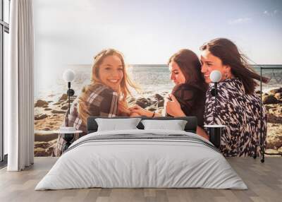 Friendship for young beautiful caucasian girls together sitting and enjoying the beach and the freedom of the ocean together - outdoo rleisure activity for millennial women Wall mural